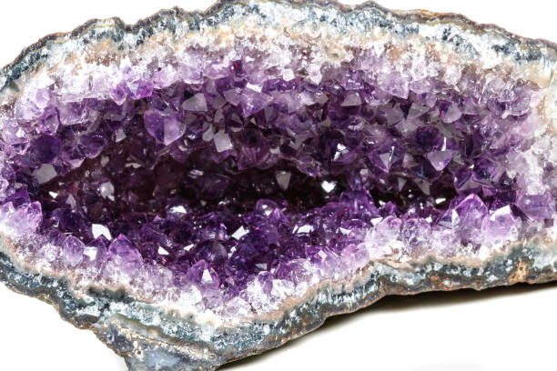 istock Macro Mineral Stone Amethysts in the rock on a white background 1072092886