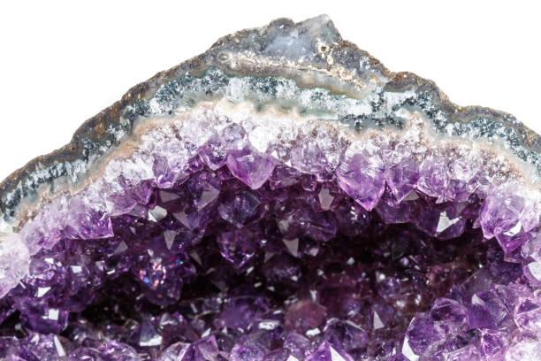 istock Macro Mineral Stone Amethysts in the rock on a white background 1072092918
