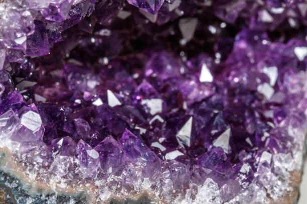 istock Macro Mineral Stone Amethysts in the rock on a white background 1072092954