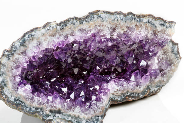 istock Macro Mineral Stone Amethysts in the rock on a white background 1072093040