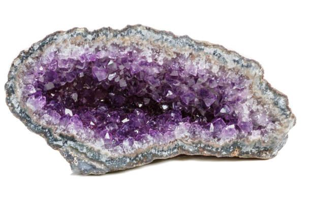 istock Macro Mineral Stone Amethysts in the rock on a white background 1072093096