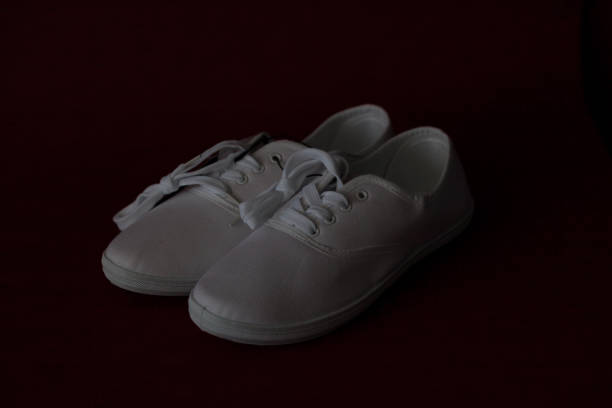 istock Pair of white sneakers standing on red background. 1072096300