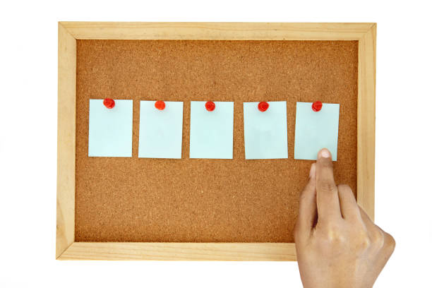 istock hand pin a note paper on a cork pin board  , isolated on white 1072096976