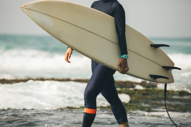 istock Woman surfer with surfboard going to surf the big waves 1072108524