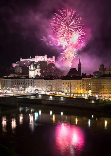 Beer Fest fireworks reflected on the river in Salzburg, Austria, and the Hohensalzburg Fortress.