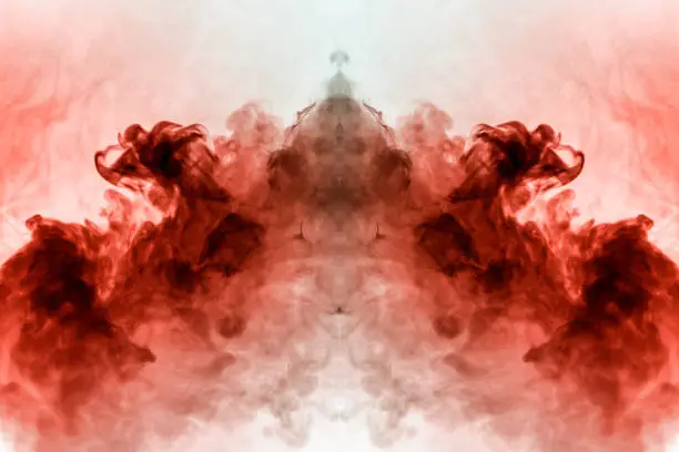 Photo of Abstract pattern of colored smoke backlit pink and red in the shape of a mystical-looking bird or a ghost-head  on a white isolated background. Soul and inner state of thoughts.