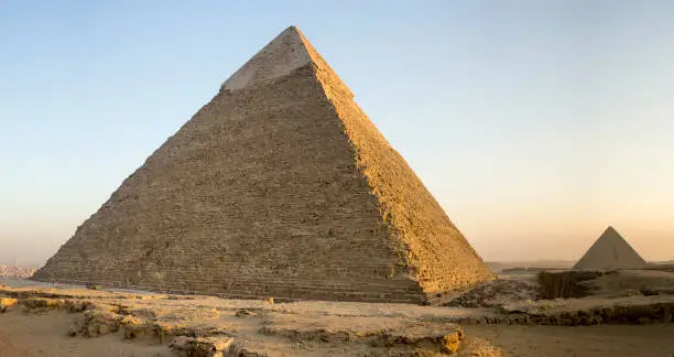 Two if the Giza Pyramids and their surrounding ruins at sunset