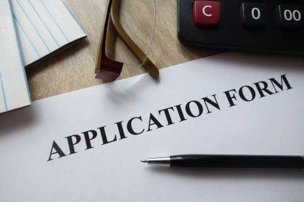 istock Application form with pen, calculator and glasses on desk 1072118056