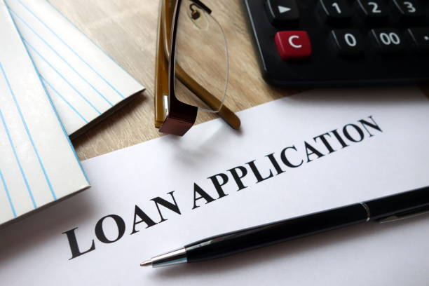 istock Loan application form with pen, calculator and glasses on desk 1072118588