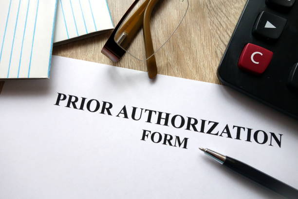 prior authorization form with pen, calculator and glasses - former imagens e fotografias de stock