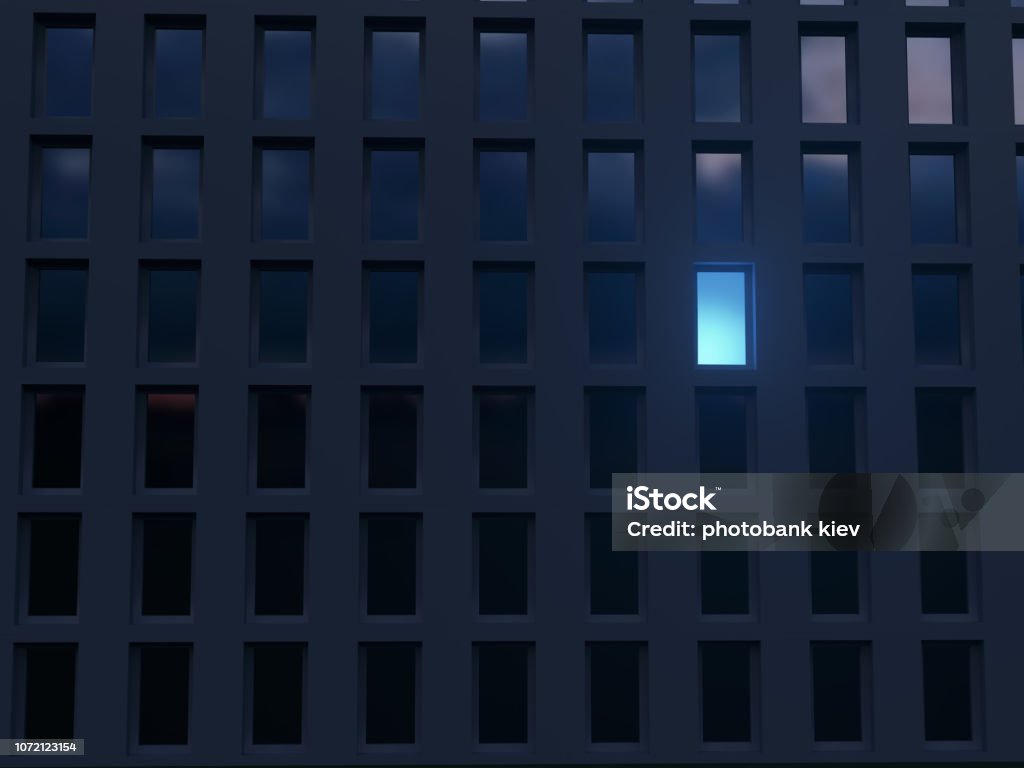 lonely luminous window in a dark house Building Exterior Stock Photo