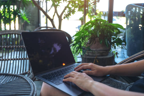 istock Closeup image of woman's hands using and typing on laptop touchpad while sitting in the outdoors 1072123160