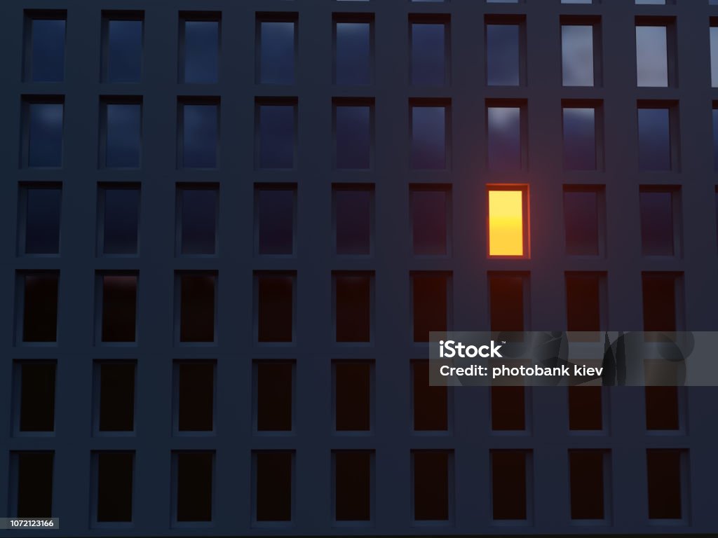 lonely luminous window in a dark house Night Stock Photo