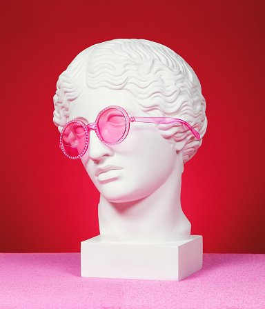 Antique head sculpture wearing pink eyeglasses