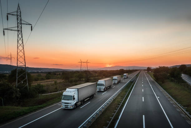 istock Four White Lorry Trucks Convoy on highway 1072140062