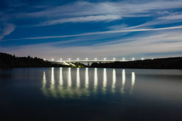 Beautiful night landscape with bridge, river and street lihgts, reflected on the water surface