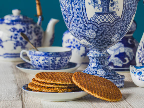 típico holandés stroopwafel casera en el fondo borroneado de porcelana tradicional de delftsblauw. - delftware fotografías e imágenes de stock