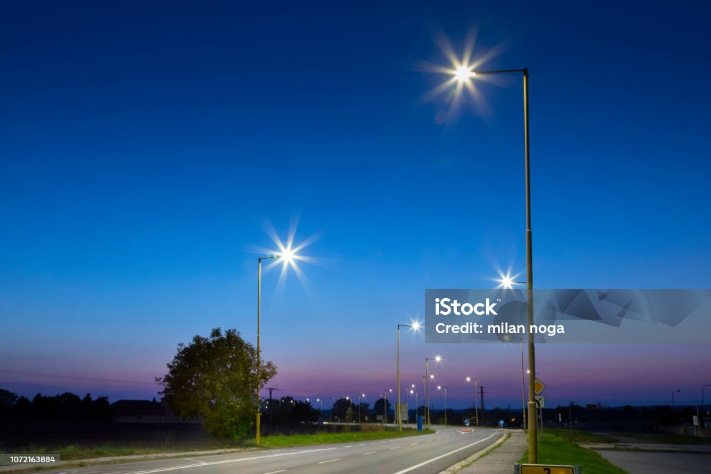 night empty road with modern LED street lights, entrance to a small town architecture, night streets Street Light Stock Photo