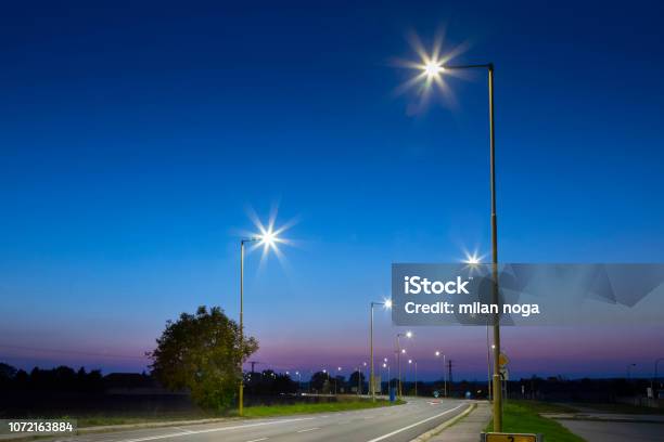 Night Empty Road With Modern Led Street Lights Entrance To A Small Town Stock Photo - Download Image Now