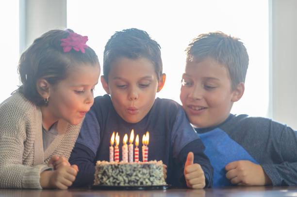 istock Siblings blow out cake candles 1072164406