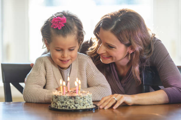 istock Mother bakes daughter a birthday cake 1072164426