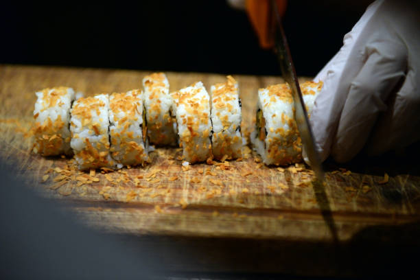 istock Sushi roll making preparation, close up on chef hands with a knife. 1072174488