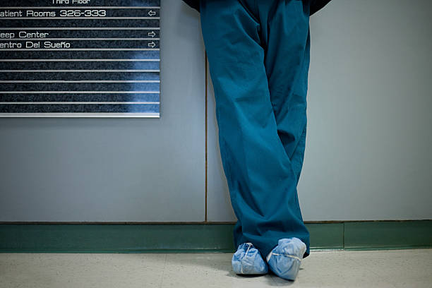 Hospital surgeon wearing shoe protectors, low section  legs crossed at ankle stock pictures, royalty-free photos & images