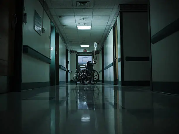 Photo of Empty wheelchair and intravenous drip in hospital corridor