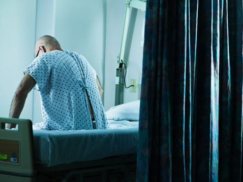 Senior hombre sentado en la cama de hospital photo