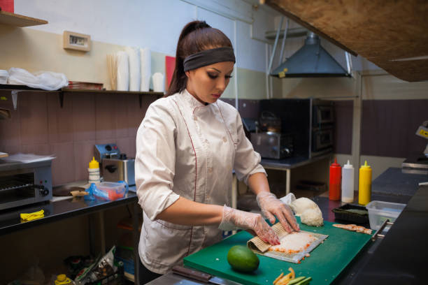 istock beautiful woman chef prepares sushi on restaurant kitchen 1072176882