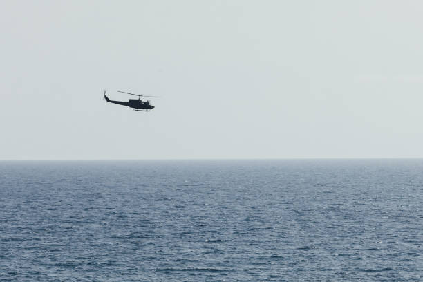 istock helicopter flying over blue sea 1072177130