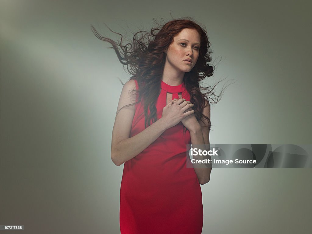 Young woman wearing red dress posing as Aphrodite, portrait  Hand On Heart Stock Photo