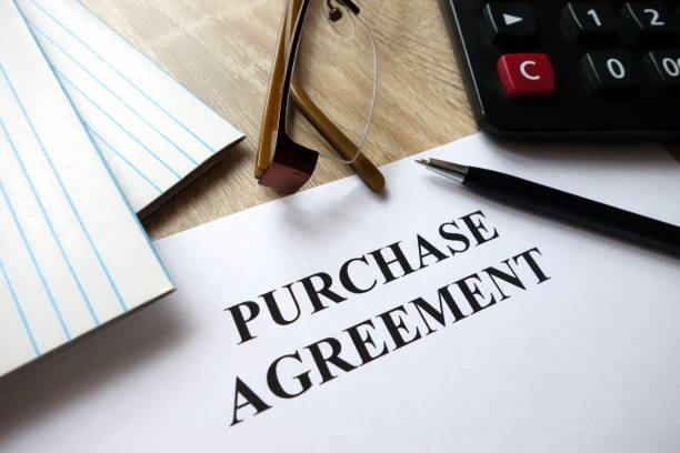 istock Purchase agreement document with pen, calculator and glasses on desk 1072179624