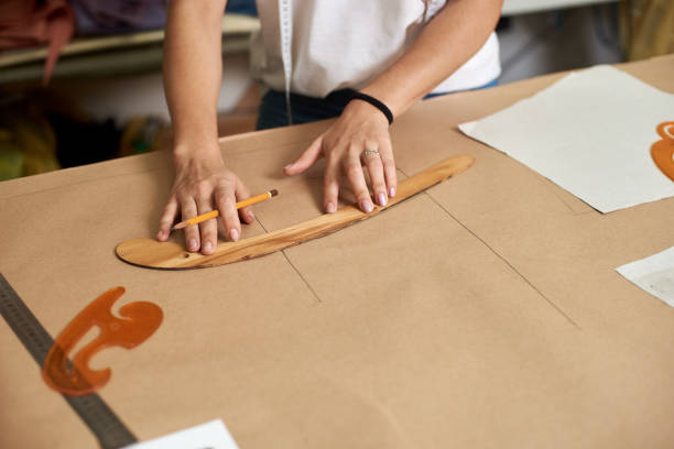 istock Workplace in modern design studio. Female designer creating exclusive flat paper clothing patterns. 1072183220