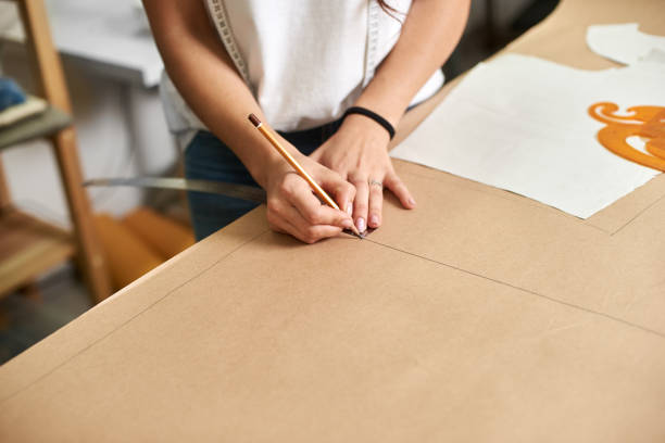 istock Workplace in modern design studio. Female designer creating exclusive flat paper clothing patterns. 1072183226