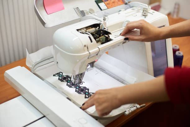 istock Close-up of sewing machine creating colorful abstract geometrical pattern on white fabric. 1072183282