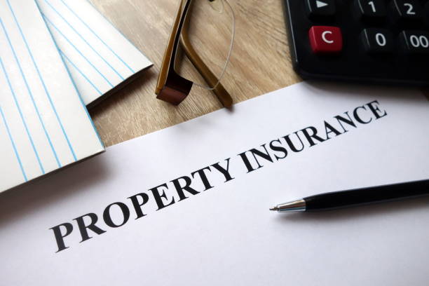 istock Property insurance document with pen, calculator and glasses on desk 1072187934