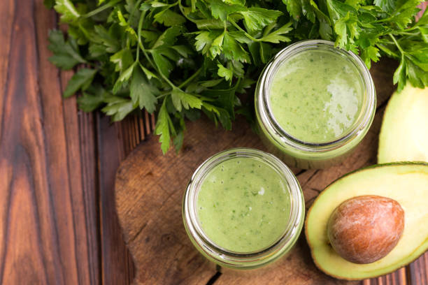 istock Fresh spinach and avocado smoothie in glass jars with parsley on old rustic cutting board 1072188176