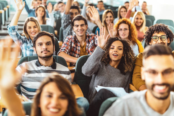 istock Happy university students raising their arms on a class at lecture hall. 1072188234