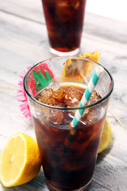 istock Softdrink with ice cubes, lemon and straw in glass 1072188406