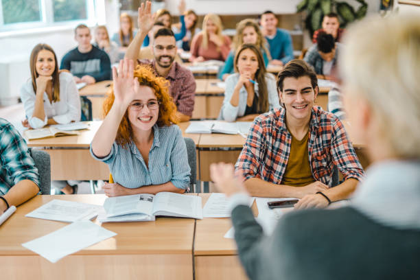 istock Happy students raising their arms on a class in the classroom. 1072191138