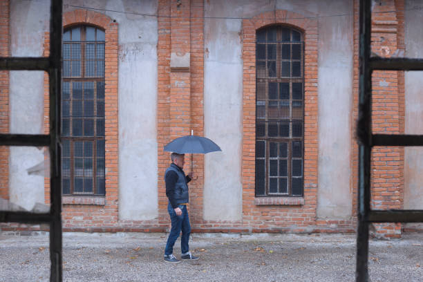 istock Adult man walking outdoors on rainy weather 1072194806