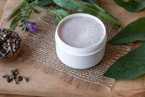 istock A jar of comfrey root ointment with fresh blooming comfrey plant and dried root 1072199816