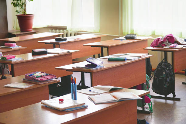 istock Empty classroom with textbooks, pencils on its desks 1072201586