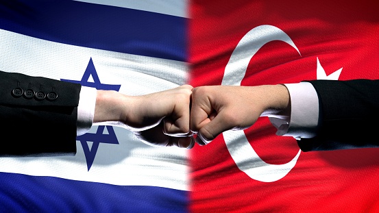 Israel vs Turkey conflict, international relations, fists on flag background