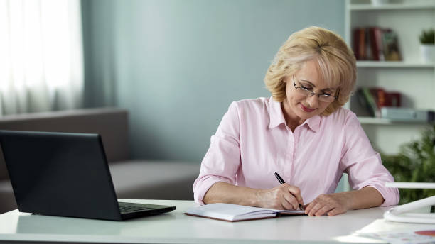 istock Business woman writing down to notebook plan for near future, freelancer work 1072203948
