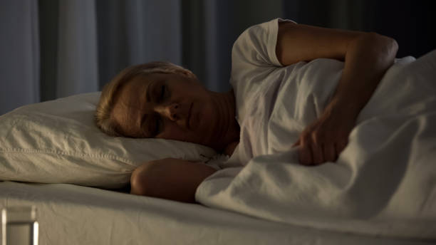 istock Female patient sleeping in hospital bed, health problem, retired age disability 1072204290