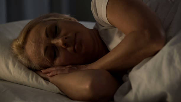 istock Middle-aged woman smiling sleeping in bed, feeling calm and bliss, night rest 1072204704