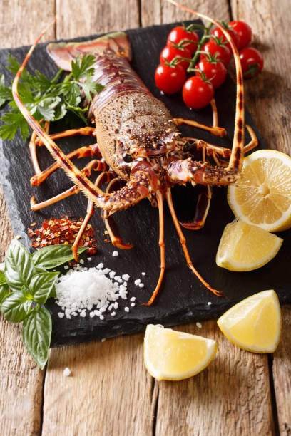 istock Raw spiny lobster with spices, vegetables ingredients close-up on a table. Vertical 1072204916