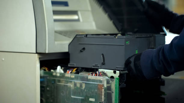 Bank employee opening ATM safe, checking breakdown, cash-in-transit service